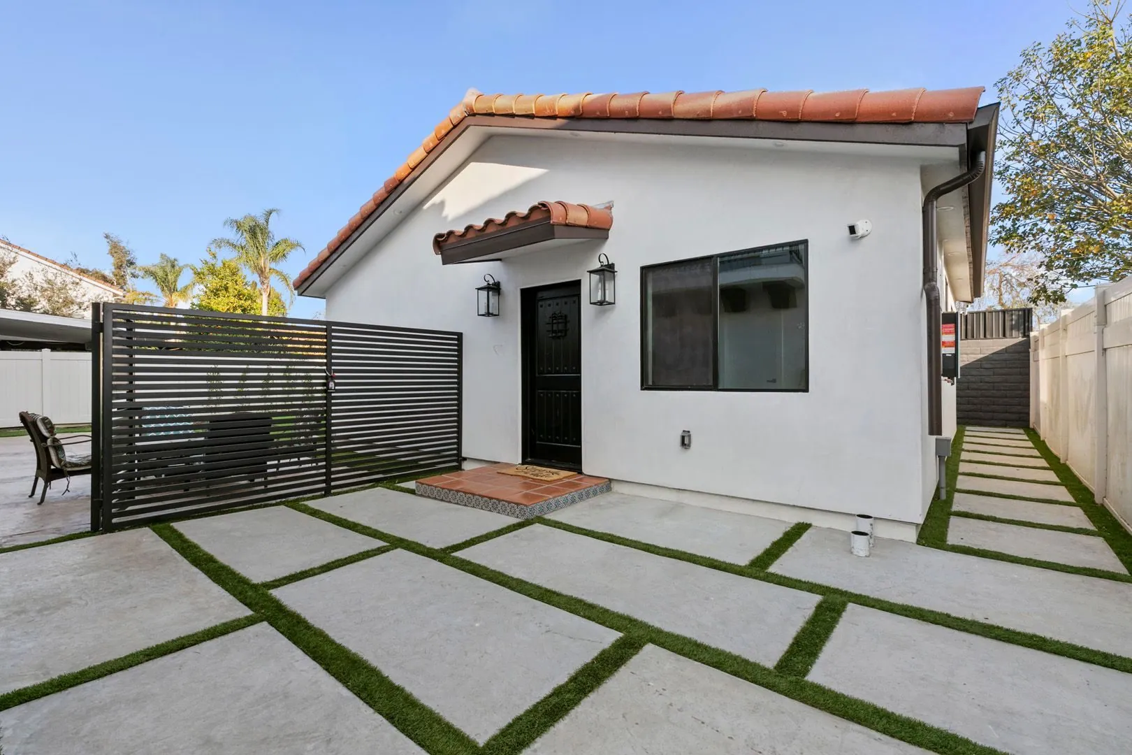 Mediterranean-style detached ADU in Los Angeles with terracotta tile roof and modern slatted gate