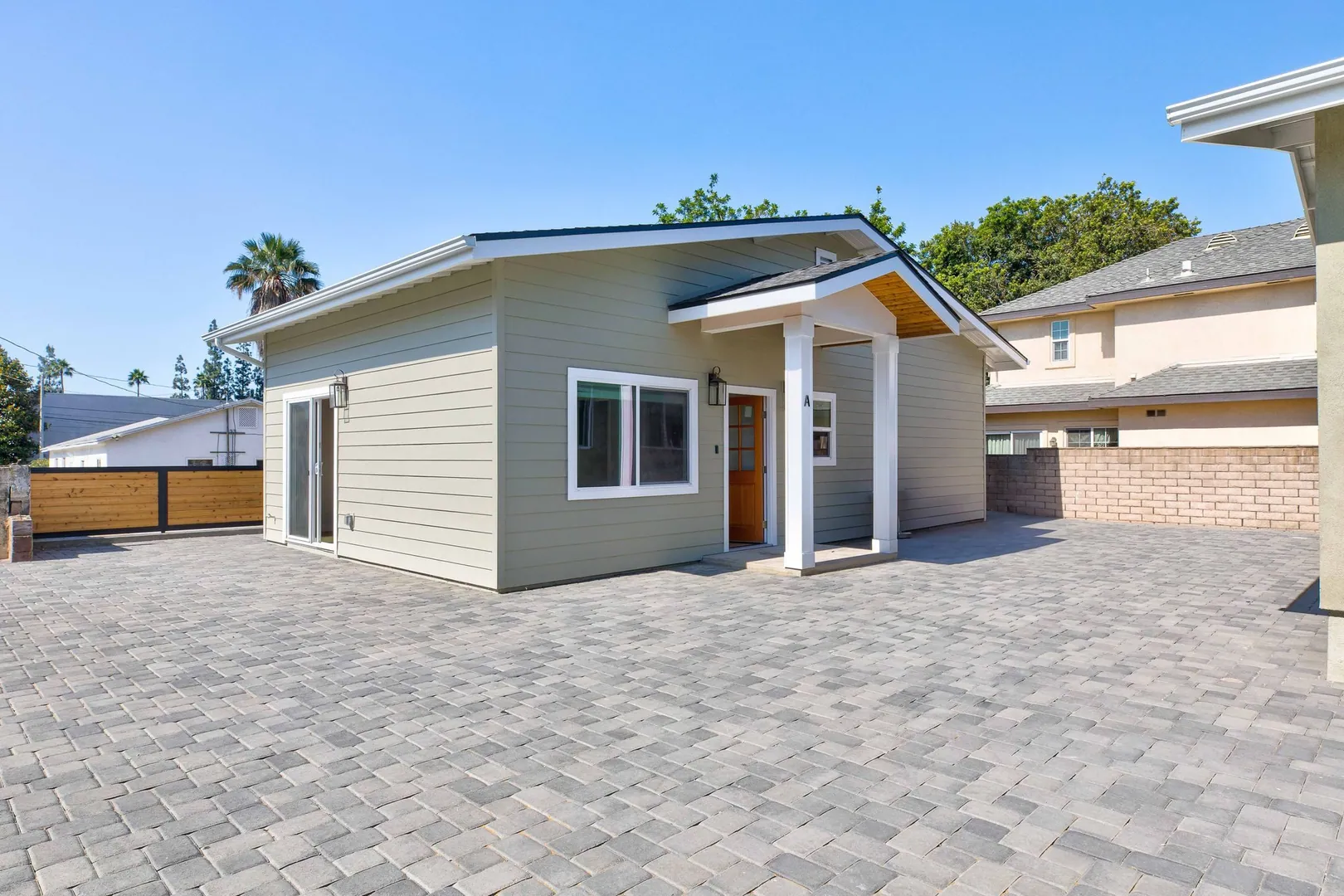 Craftsman-style detached ADU in Monrovia with sage green siding, gabled porch and paver driveway